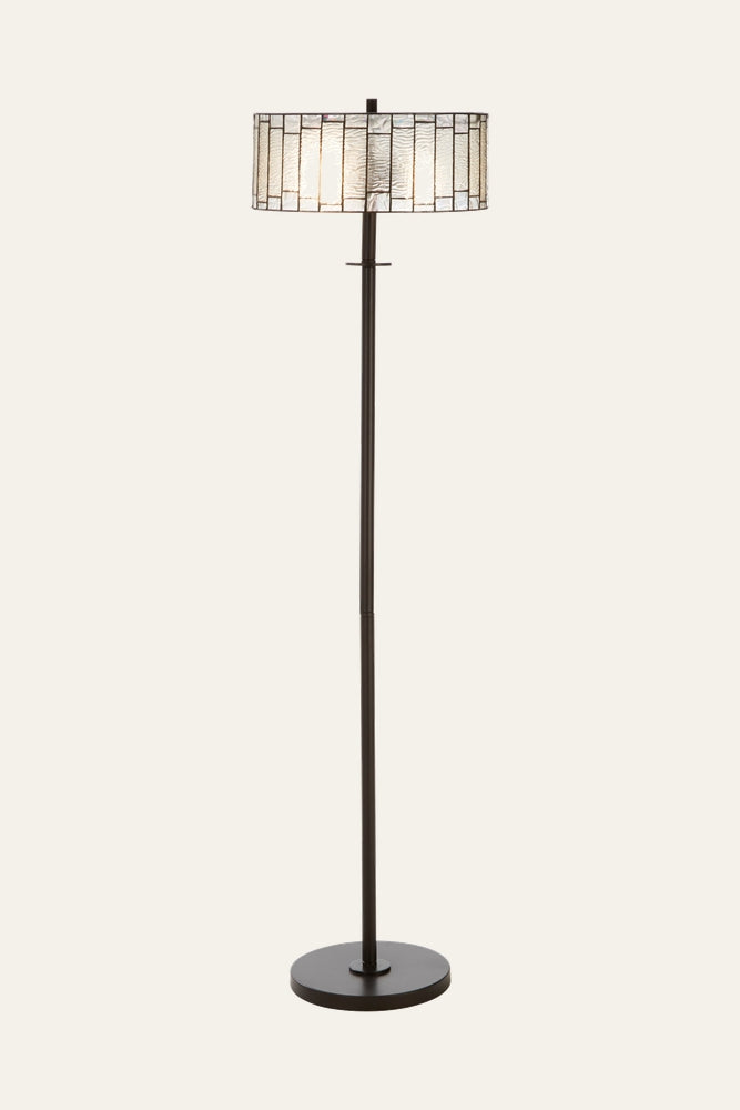 Evaya Open Frame Floor Lamp with dark bronze metal pole and round base and an open‑frame textured glass drum shade with metal grid, shown lit