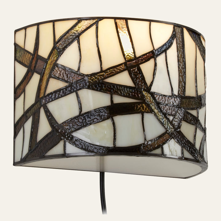 Evaya Wall Light — curved stained-glass drum shade with cream panels and dark textured leaded swirl pattern, black cord visible