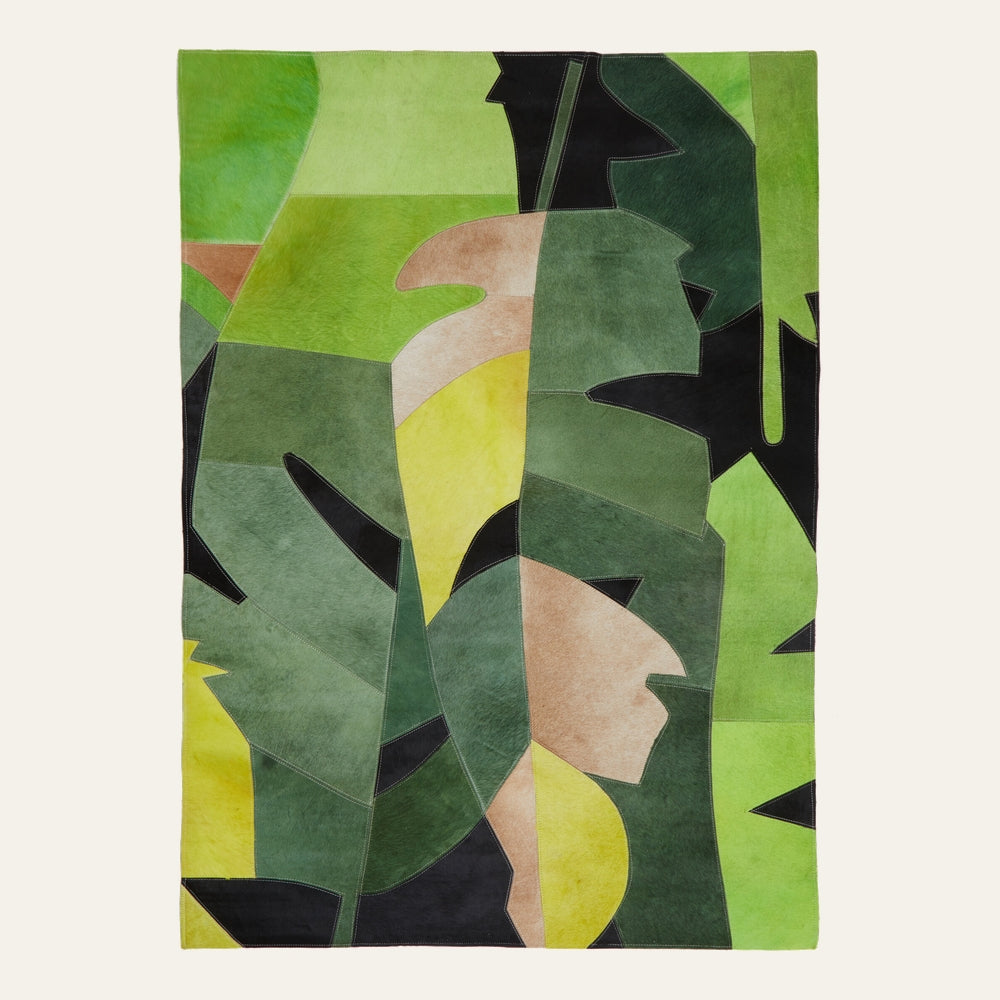 Ezelle Botanical Leather Rug — rectangular patchwork leather rug with abstract botanical leaf shapes in shades of green, yellow, tan and black, hair-on-hide texture with visible stitched seams