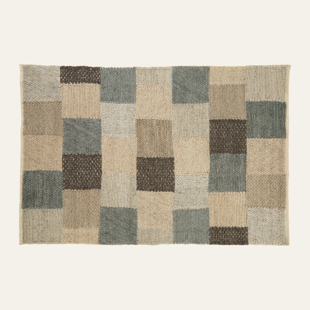 Ezelle Grid Design Rug — rectangular textured woven rug with a patchwork grid of squares in beige, tan, taupe, gray-blue and dark brown