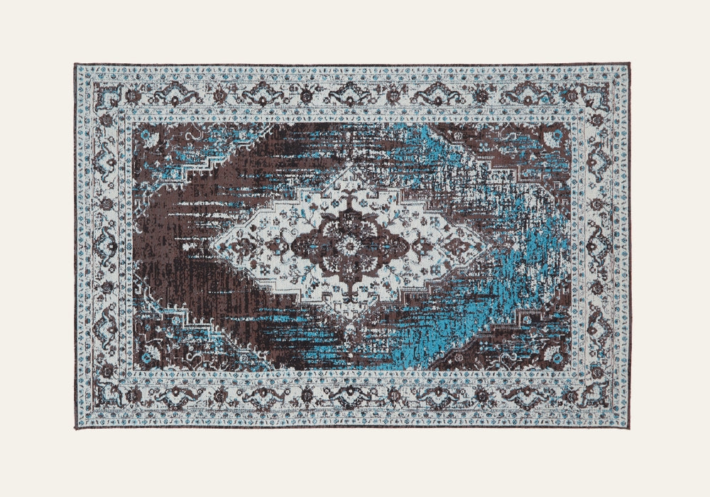 Ezelle Rug | Morvi Rug — rectangular rug with distressed central medallion, ornate cream border, brown field and teal-blue accents.