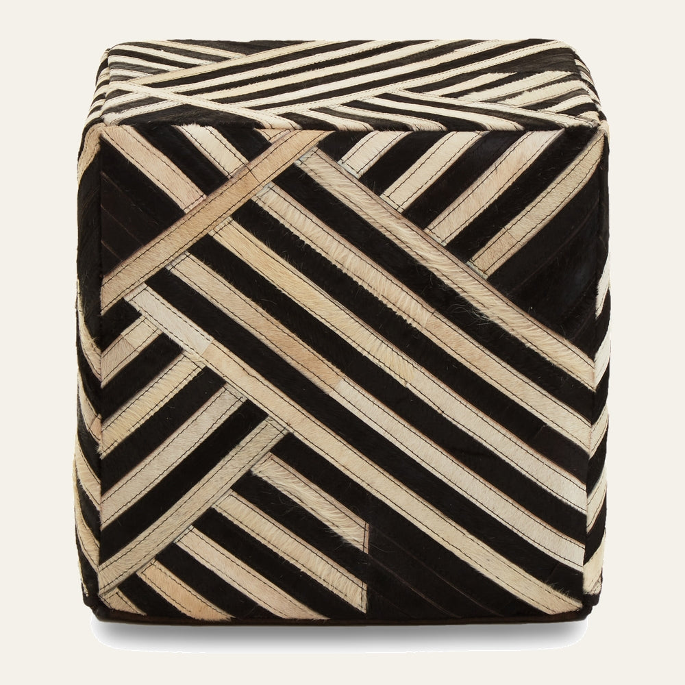 Ezelle Striped Leather Pouffe — cube pouf covered in black and natural hair-on leather strips arranged in a diagonal geometric stripe pattern.