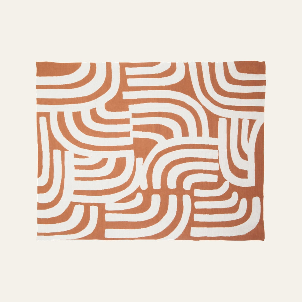 Ezelle Throw | Ozella Throw — flat-lay rectangular throw with terracotta-orange background and bold white rounded geometric stripe pattern