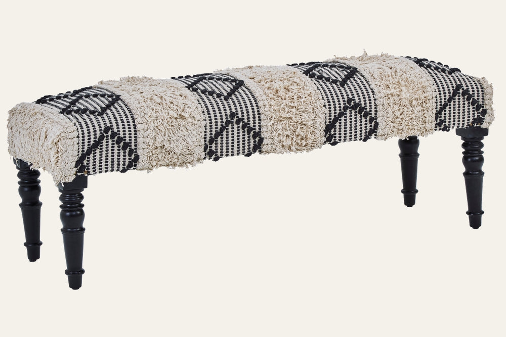 Fenlor Bench upholstered in alternating cream shag and black-and-cream woven geometric panels, supported by turned black wooden legs