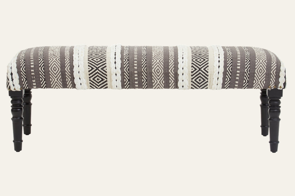 Fenlor Open Frame Bench with gray-and-cream woven geometric striped upholstery, braided cream accents, and turned black wooden legs.