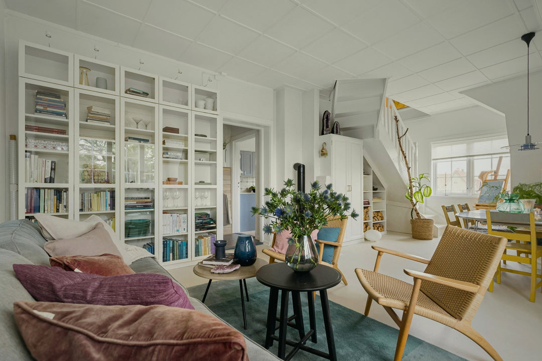 Living room with white bookshelves, a sofa, and a dining area.