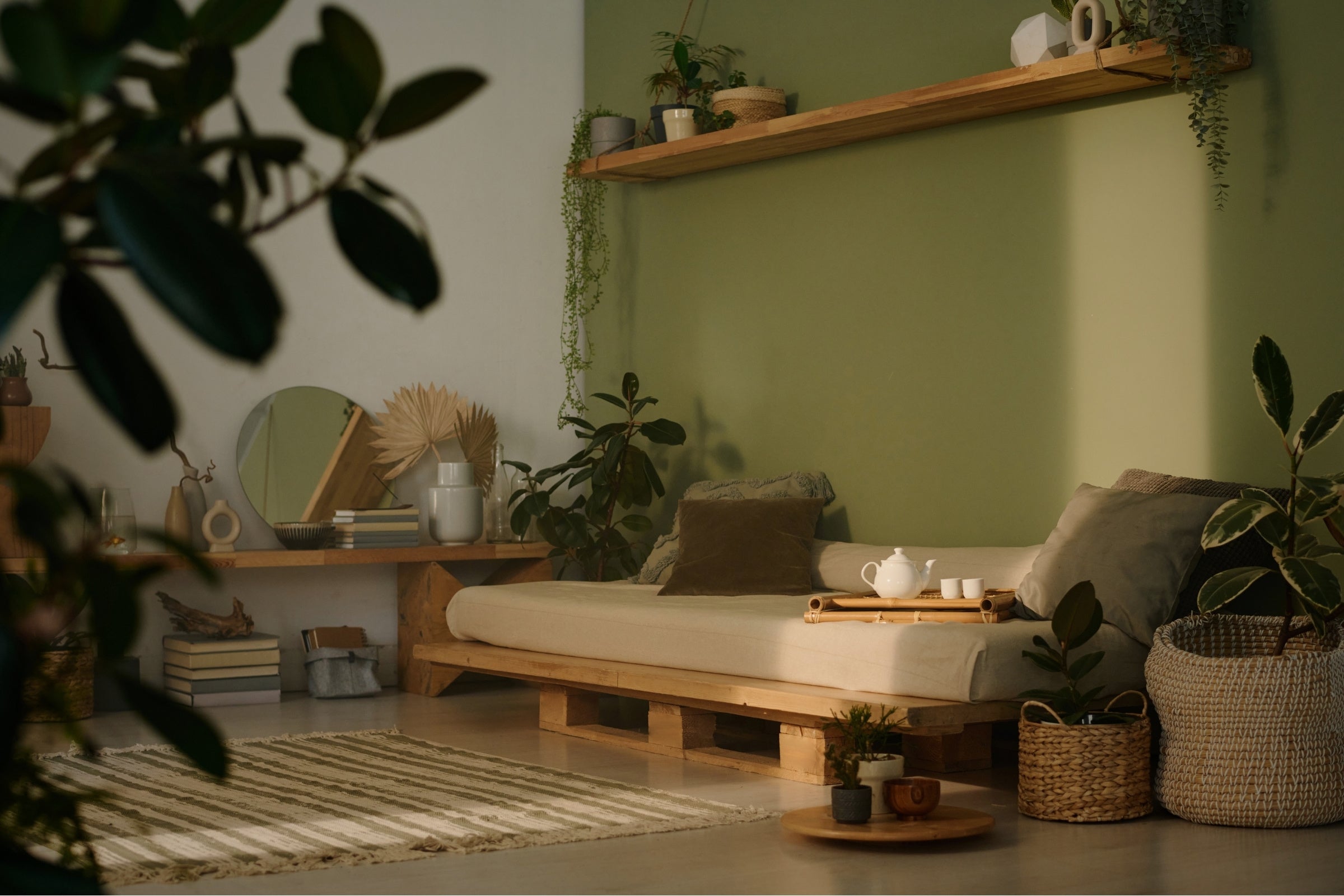 Cozy living room with wooden pallet sofa, plants, and shelves.