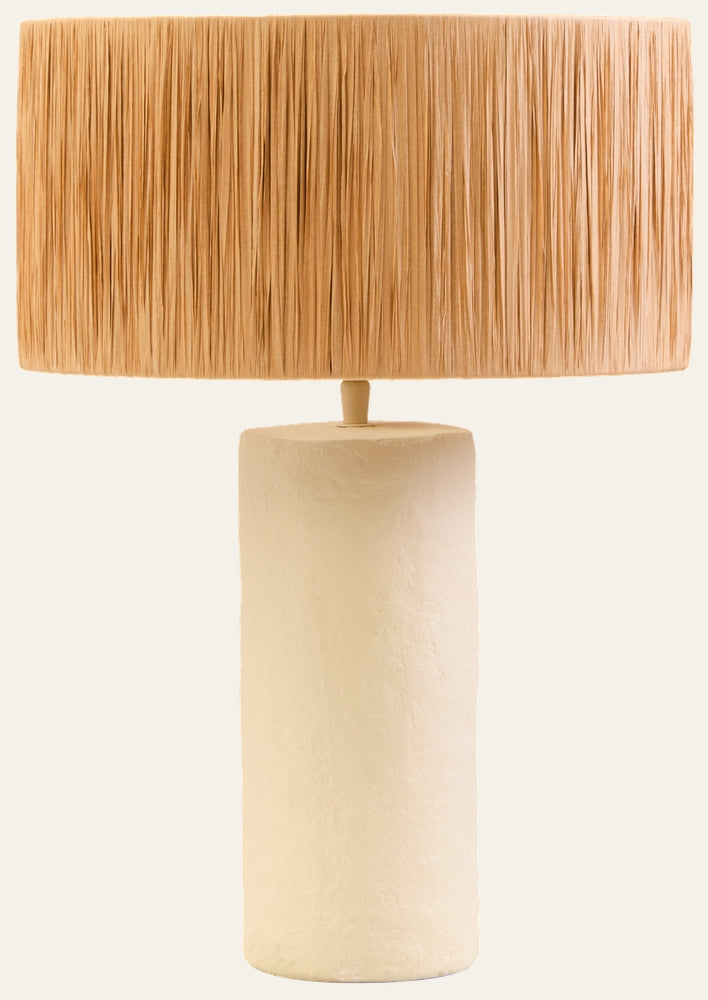 Irdan Table Lamp — tall textured off-white cylindrical base with a wide natural straw fringe drum shade
