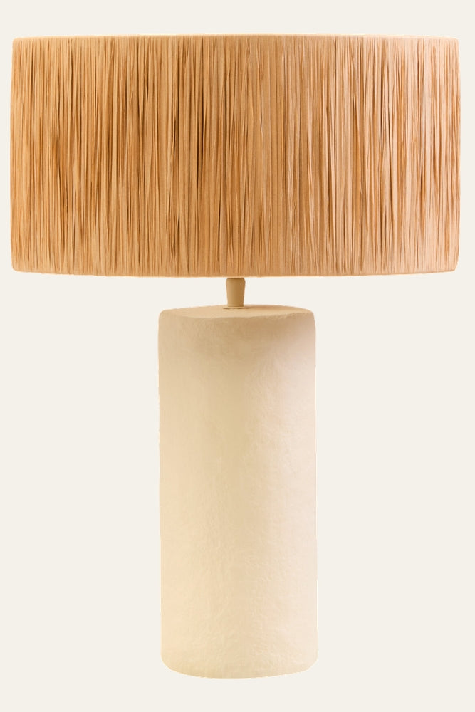 Irdan Table Lamp with tall matte cream textured cylindrical base and wide natural raffia fringe drum shade