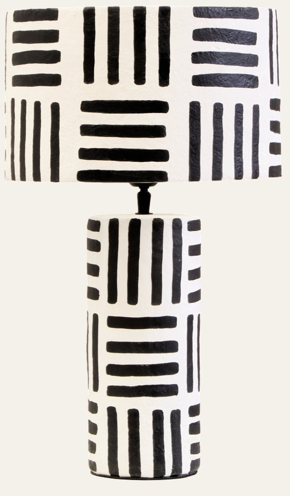 Irdan Table Lamp — tall cylindrical textured white base with black brushstroke vertical and horizontal stripes, topped by a matching patterned drum shade