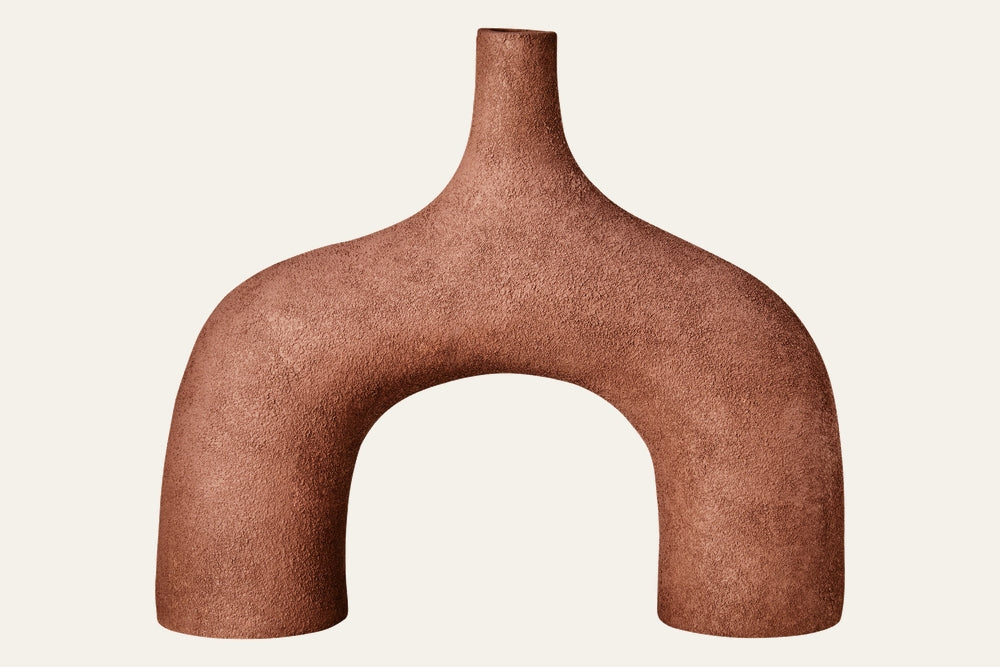 Isola Textured Abstract Vase — arch-shaped, terracotta-toned vase with narrow neck and rough, textured matte finish.