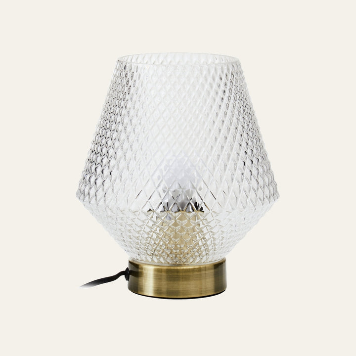Lysara Table Lamp with faceted clear diamond-pattern glass shade, brushed brass round base, visible bulb and black cord