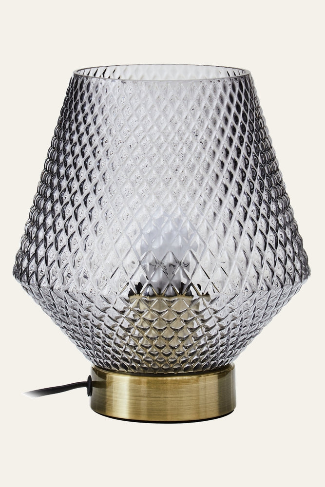 Lysara Table Lamp with diamond-patterned smoked glass shade, visible bulb, brushed brass cylindrical base and black cord