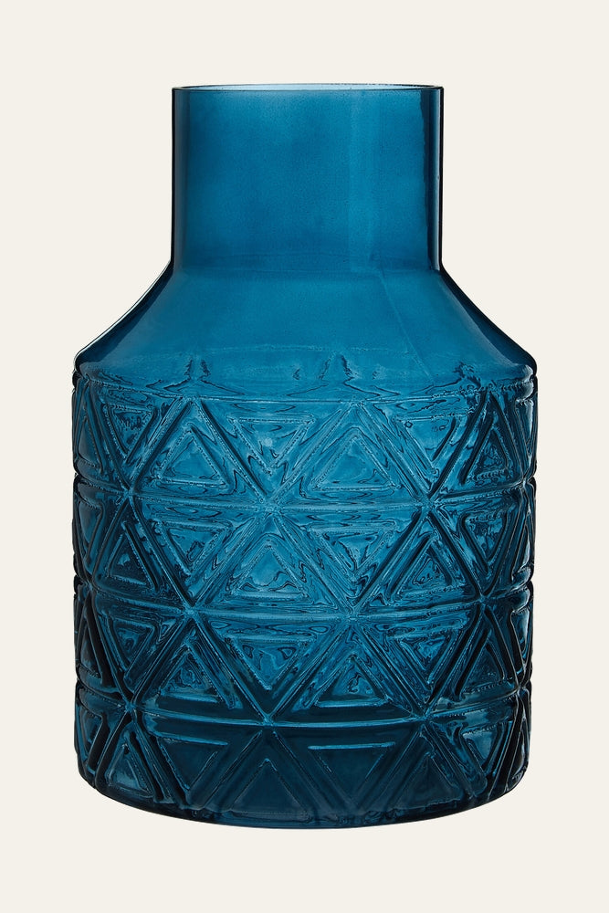Maelis Blue Glass Vase — translucent deep blue glass vase with short cylindrical neck and embossed geometric triangle pattern on the rounded body.