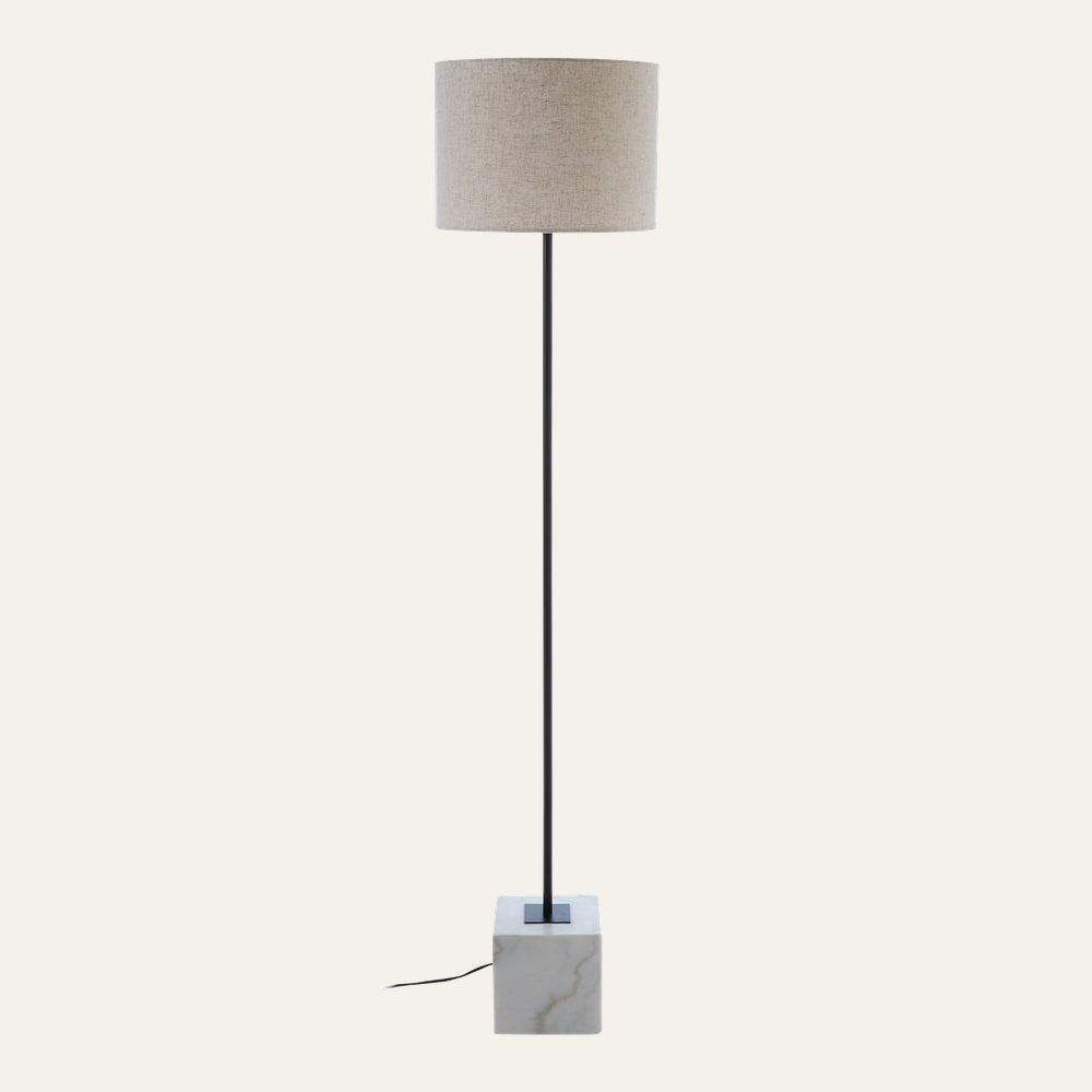 Miro Marble Base Floor Lamp with slim black metal stem rising from a square white marble base with subtle veining, topped by a beige fabric drum shade
