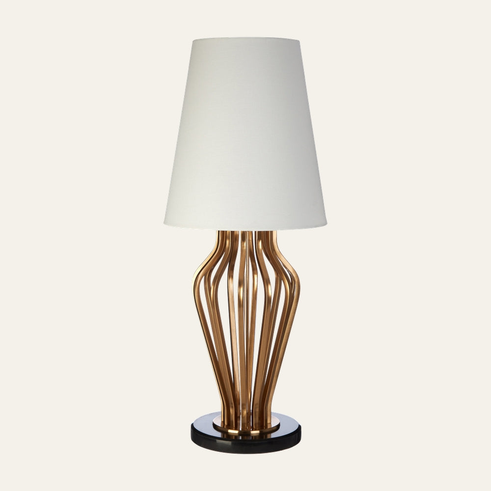 Nerdan Angular Table Lamp with white tapered fabric shade, sculptural angular gold-finish metal rod base and round black base