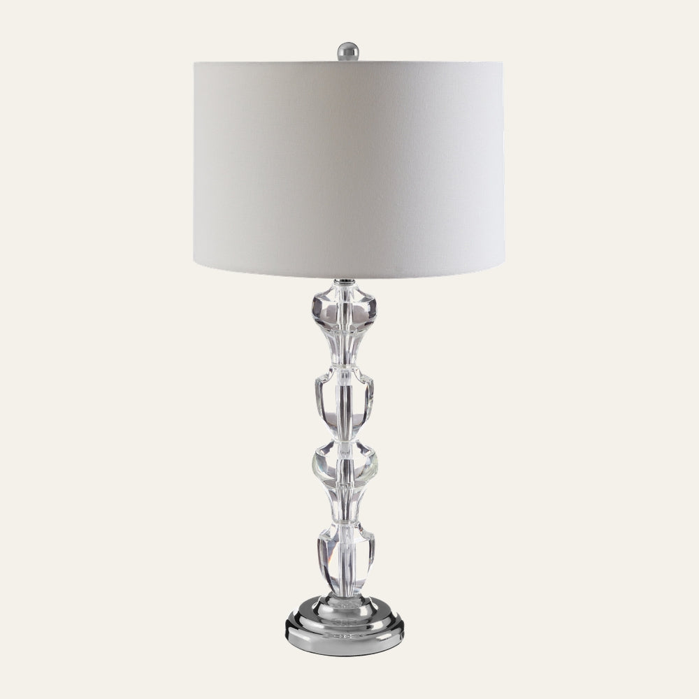 Nolina Crystal Glass Table Lamp with stacked faceted clear crystal glass column, white drum fabric shade, and polished chrome round base with chrome finial