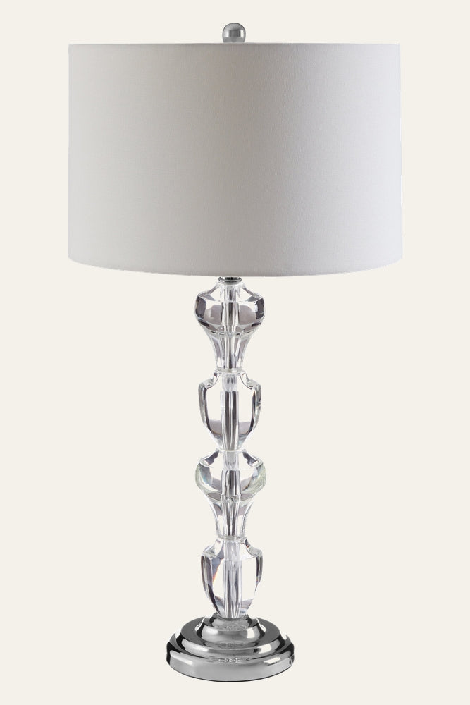Nolina Crystal Glass Table Lamp with white drum fabric shade, stacked clear crystal glass stem, polished chrome round base and silver finial