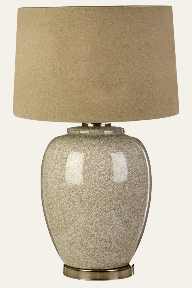 Orielle Ceramic Table Lamp with rounded crackle-glazed beige ceramic base, brass-finish metal foot and neck, topped with a natural linen tapered drum shade.