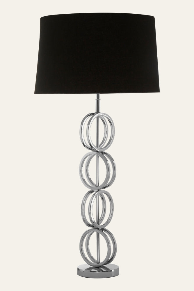 Selva Multi Ring Table Lamp with four stacked chrome rings on a polished metal base and a large black fabric drum shade