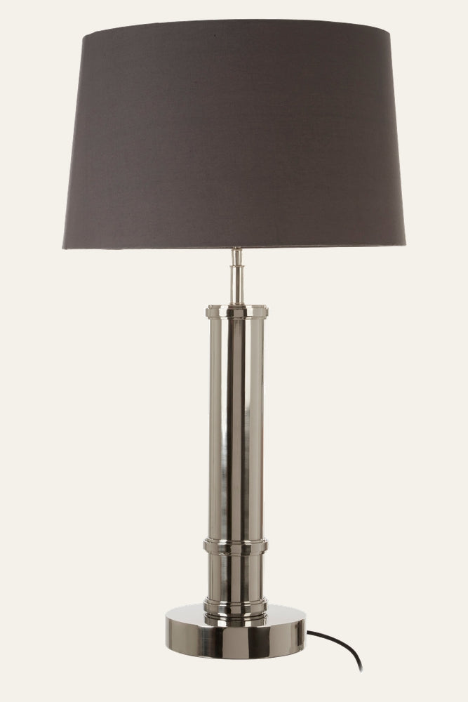 Selva Tubular Base Table Lamp with polished chrome tubular metal base and round pedestal, topped by a dark gray fabric drum shade with visible black power cord
