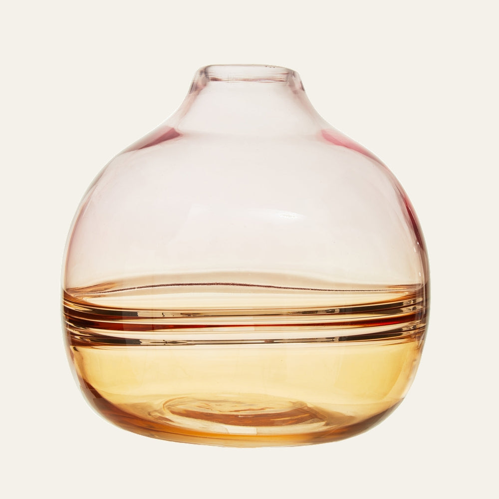 Sora Glass Bottle Vase — round bulbous glass bottle with short narrow neck, transparent pink-to-amber finish and horizontal ribbed bands around the middle.
