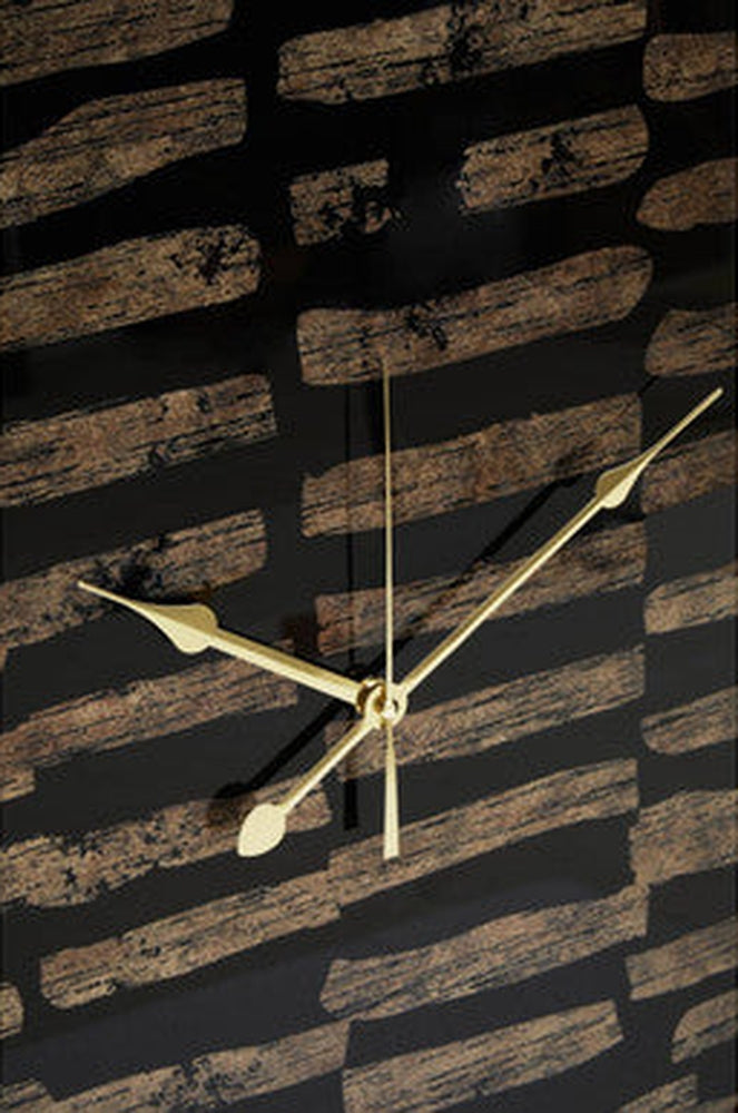 Soren Wall Clock close-up of glossy black face with distressed brown horizontal brush-stroke pattern and gold metal clock hands