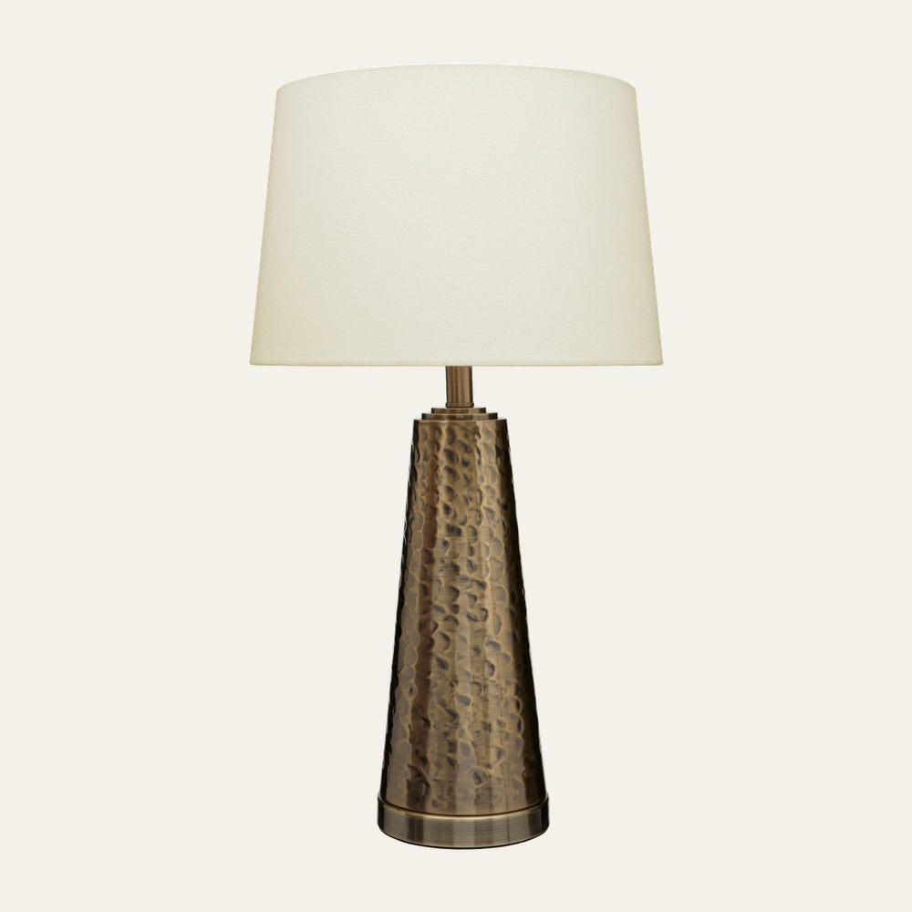 Soreva Brass Table Lamp with hammered tapered brass base and off-white fabric drum shade