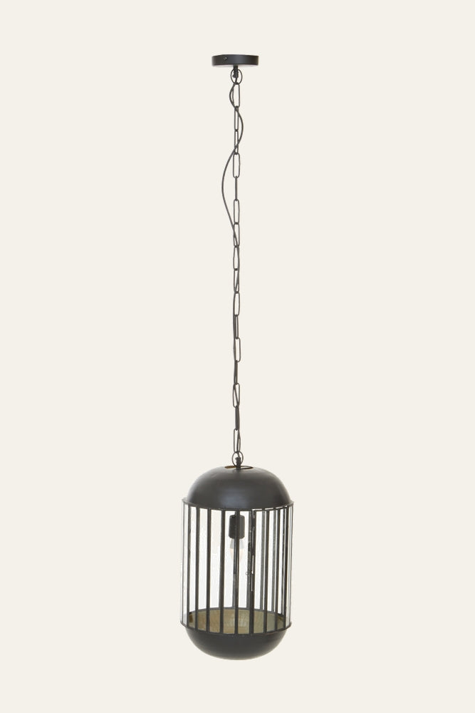 Velena Glass Pendant Light — cylindrical clear glass pendant with vertical black metal cage, domed black metal top and bottom, exposed bulb visible inside, suspended from a matching chain