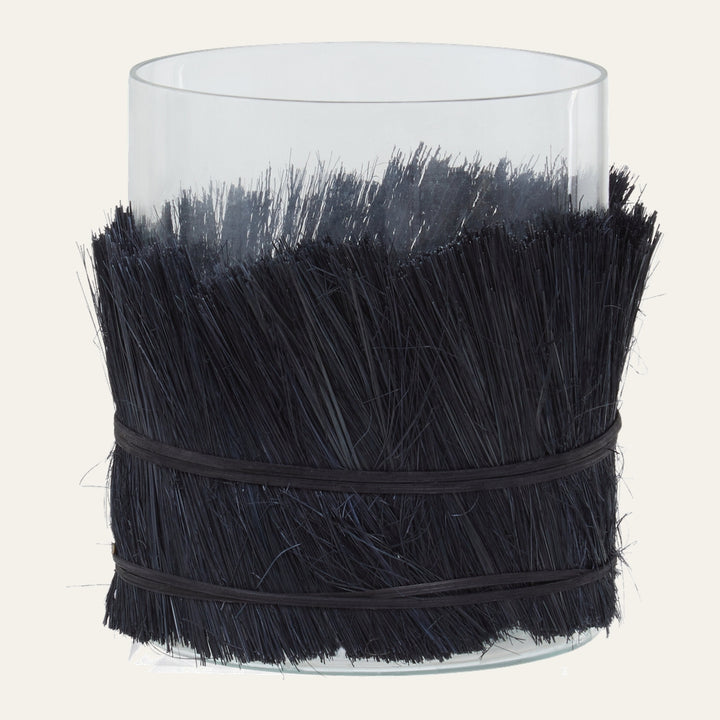 Velora Candle Holder clear glass cylinder wrapped mid-height in dense black straw-like bristles, secured with two thin black bands