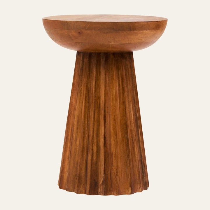 Wesric Carved Ridge Side Table with a round thick wooden top and carved, fluted tapered pedestal base in warm brown wood grain finish