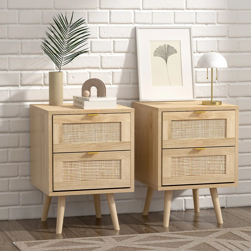 Two wooden nightstands with rattan drawers against a white brick wall.