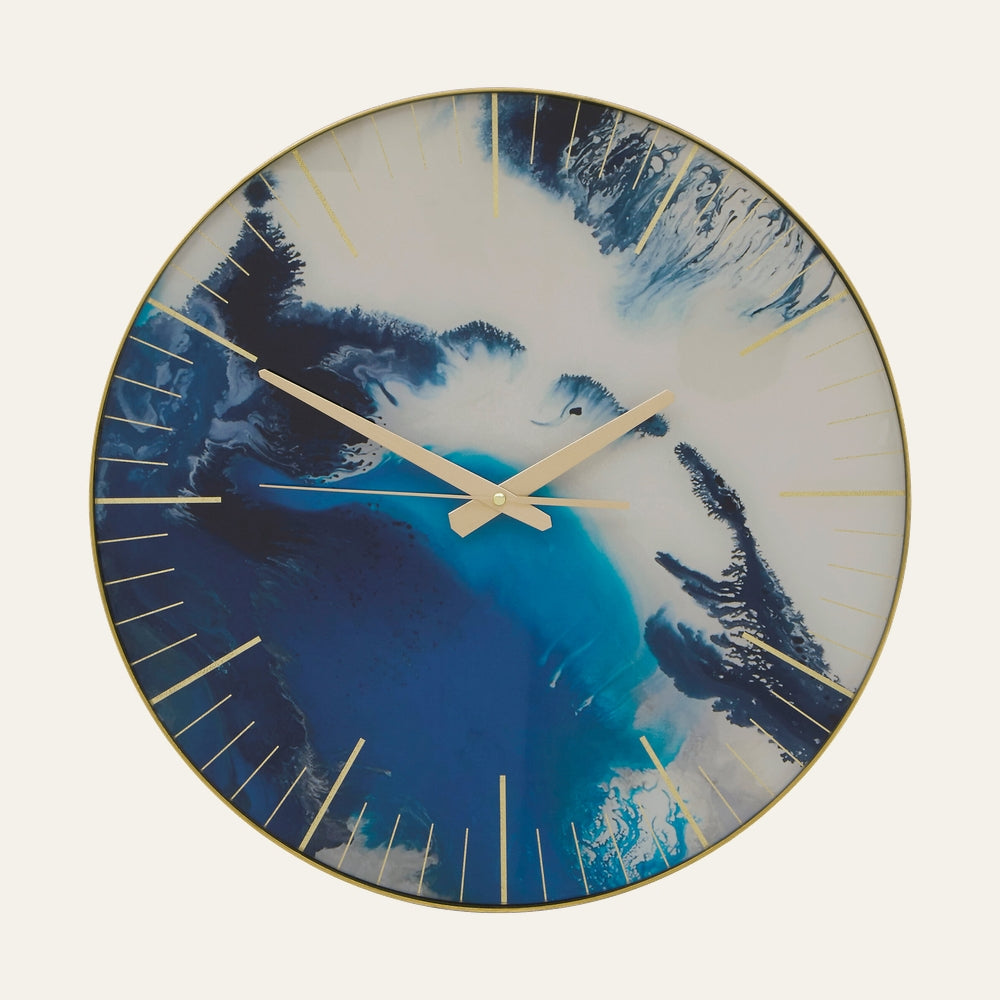 Xandor Round Clock — round wall clock with blue and white abstract swirl face, slim gold hour markers, gold metal hands and thin gold frame