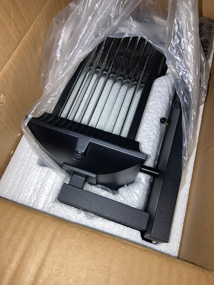 Close-up of black outdoor wall light with ribbed glass panels in protective warehouse packaging